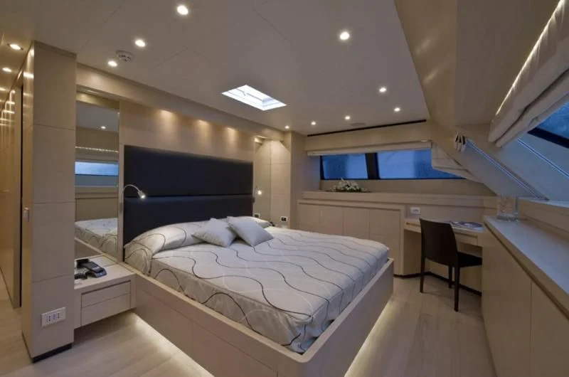 a room with a bed and a desk aboard ELYSIUM Yacht for Sale