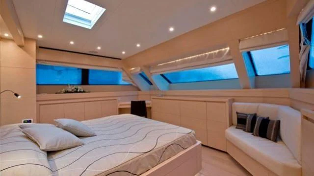 a room with a bed and a window aboard ELYSIUM Yacht for Sale