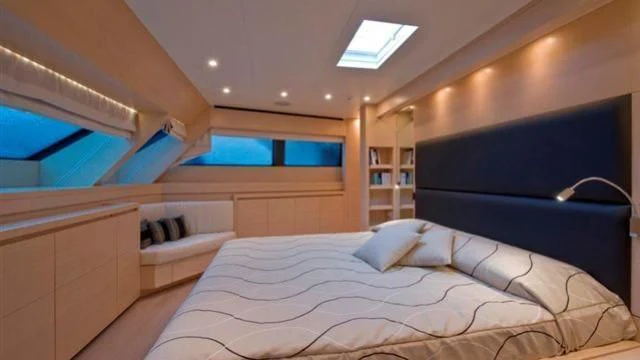 a room with a bed and a tv aboard ELYSIUM Yacht for Sale