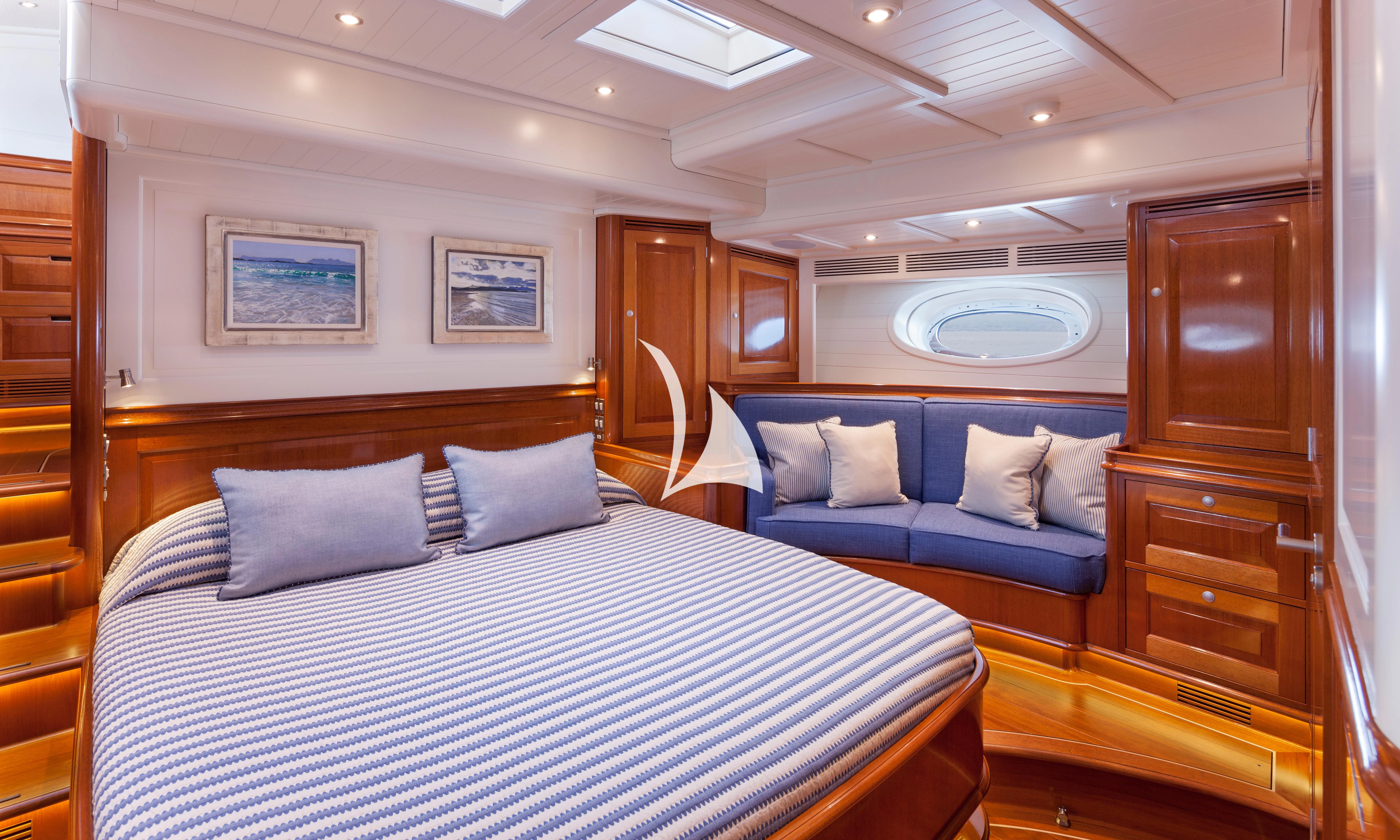 a room with a bed and a wood cabinet aboard ATALANTE Yacht for Sale