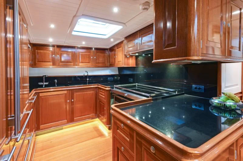 a kitchen with wooden cabinets aboard ATALANTE Yacht for Sale