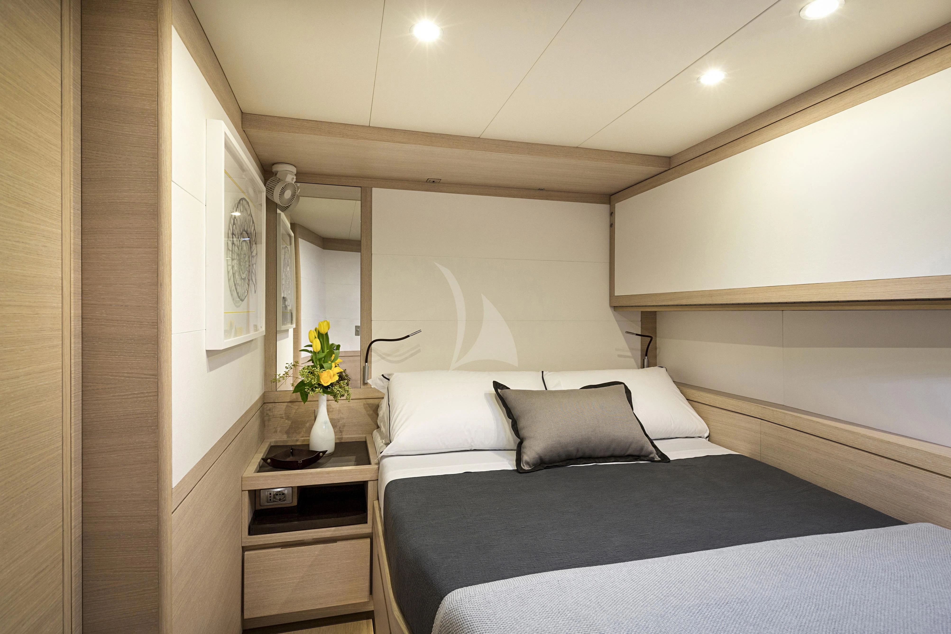 a bed with a blue bed spread aboard AMMONITE Yacht for Charter