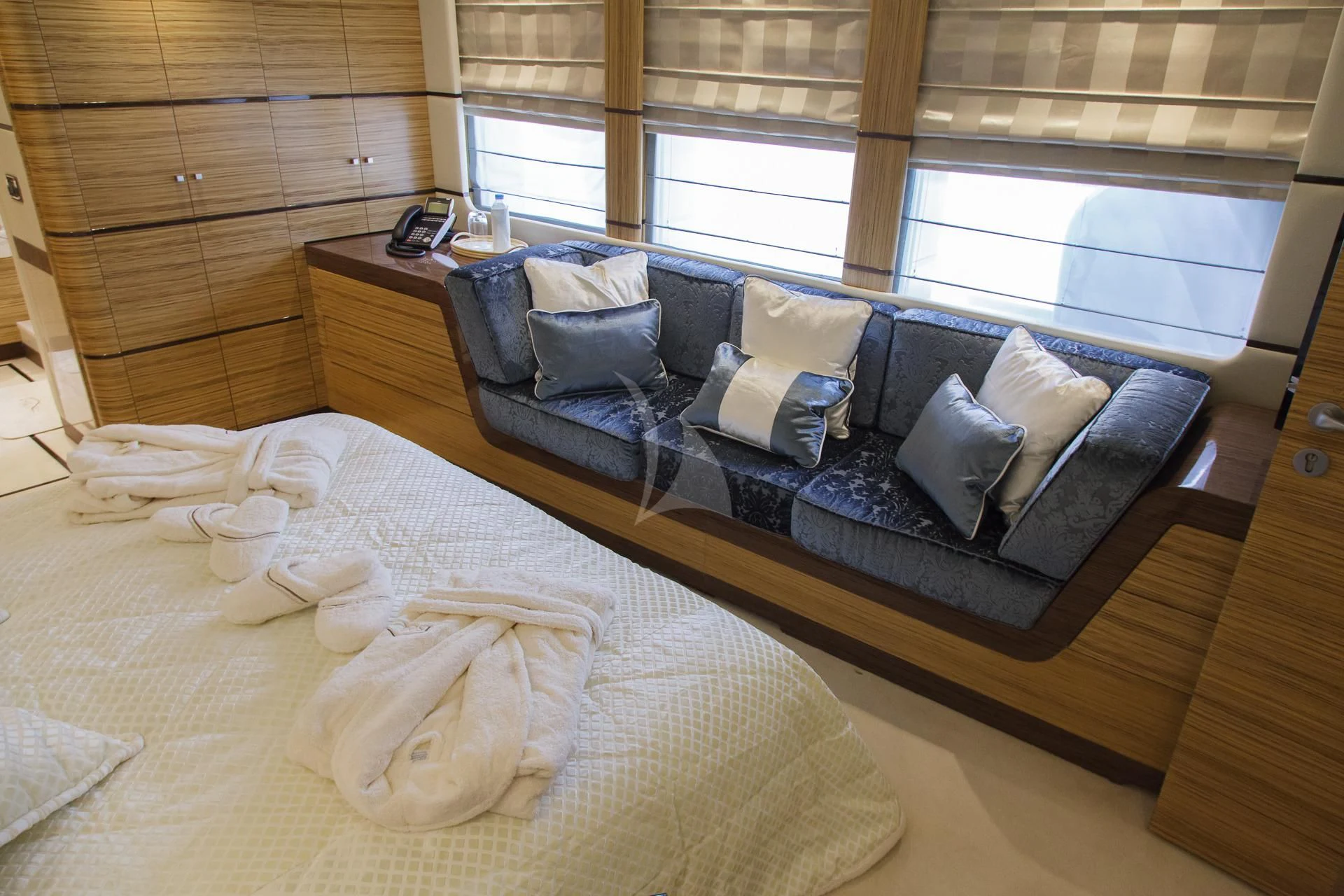 a bed with a couch and pillows aboard I SEA Yacht for Charter