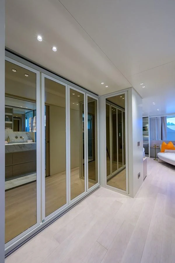 a room with glass walls and a wood floor and a large window aboard PEARL Yacht for Sale