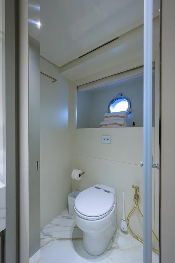 a toilet with a window above it aboard PEARL Yacht for Sale