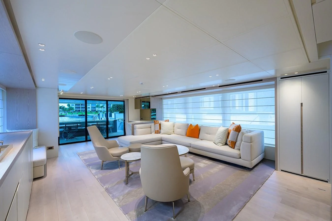 a living room with a large white sofa and a large window aboard PEARL Yacht for Sale