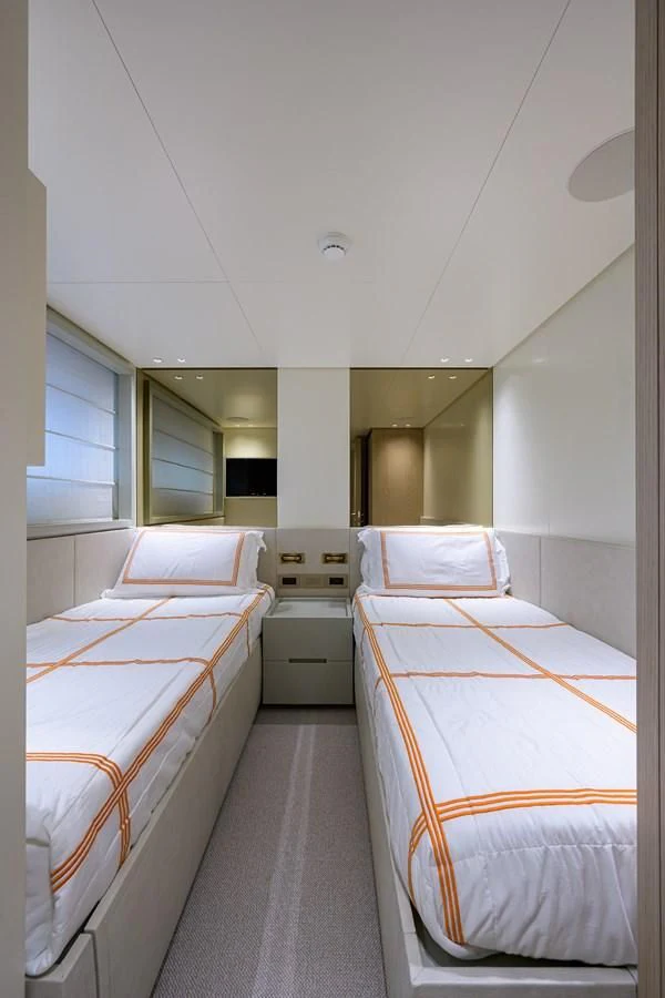 a room with beds and a mirror aboard PEARL Yacht for Sale
