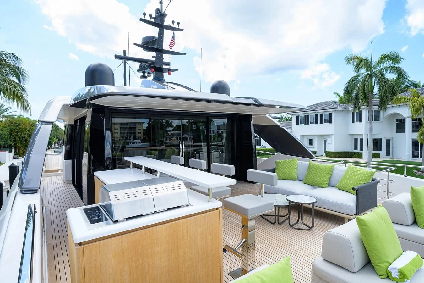 a deck with a pool and lounge chairs and a large building with a slide and a slide on aboard PEARL Yacht for Sale