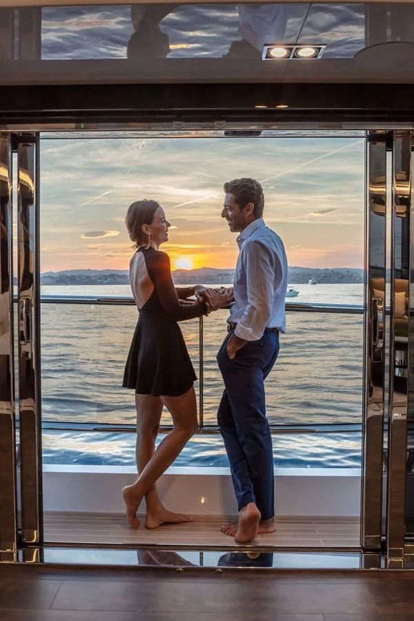 a man and woman standing on a dock looking at each other aboard PEARL Yacht for Sale