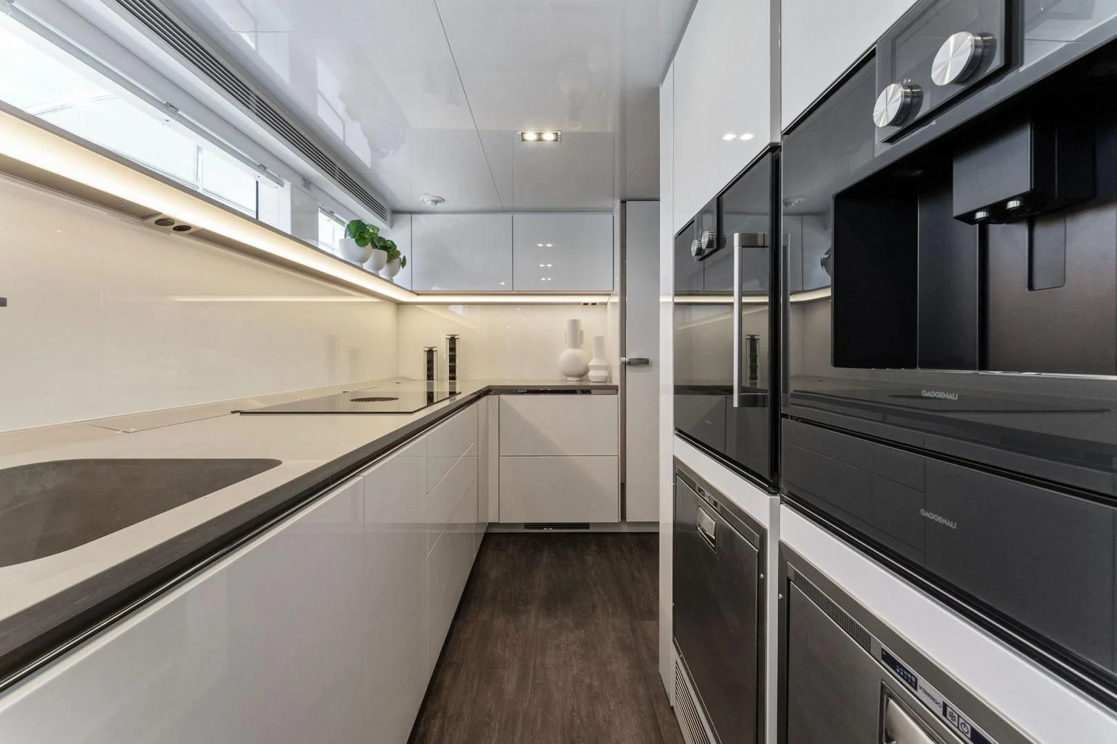 a kitchen with black cabinets aboard PEARL Yacht for Sale
