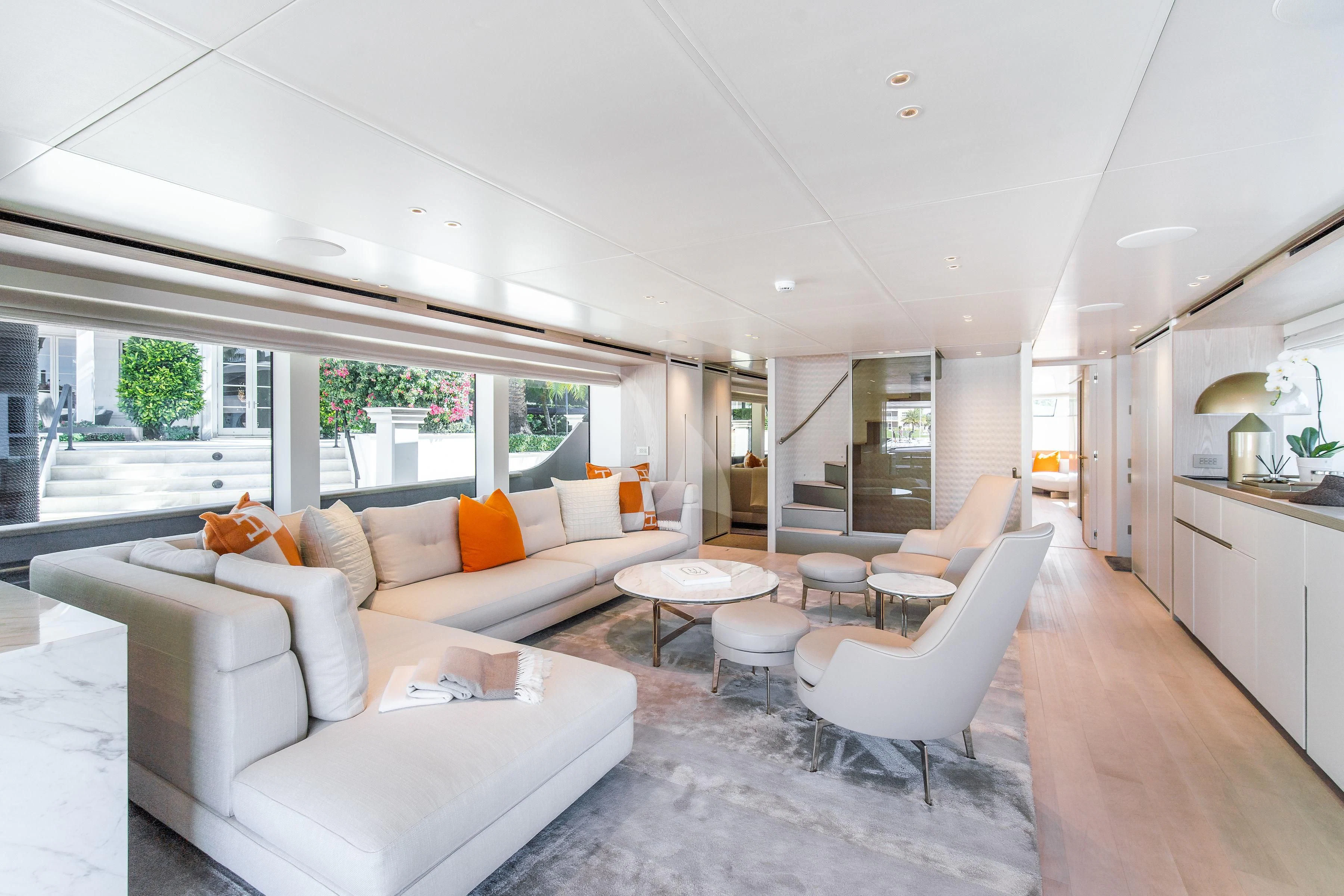 a living room with a large white sofa and a large window aboard PEARL Yacht for Sale