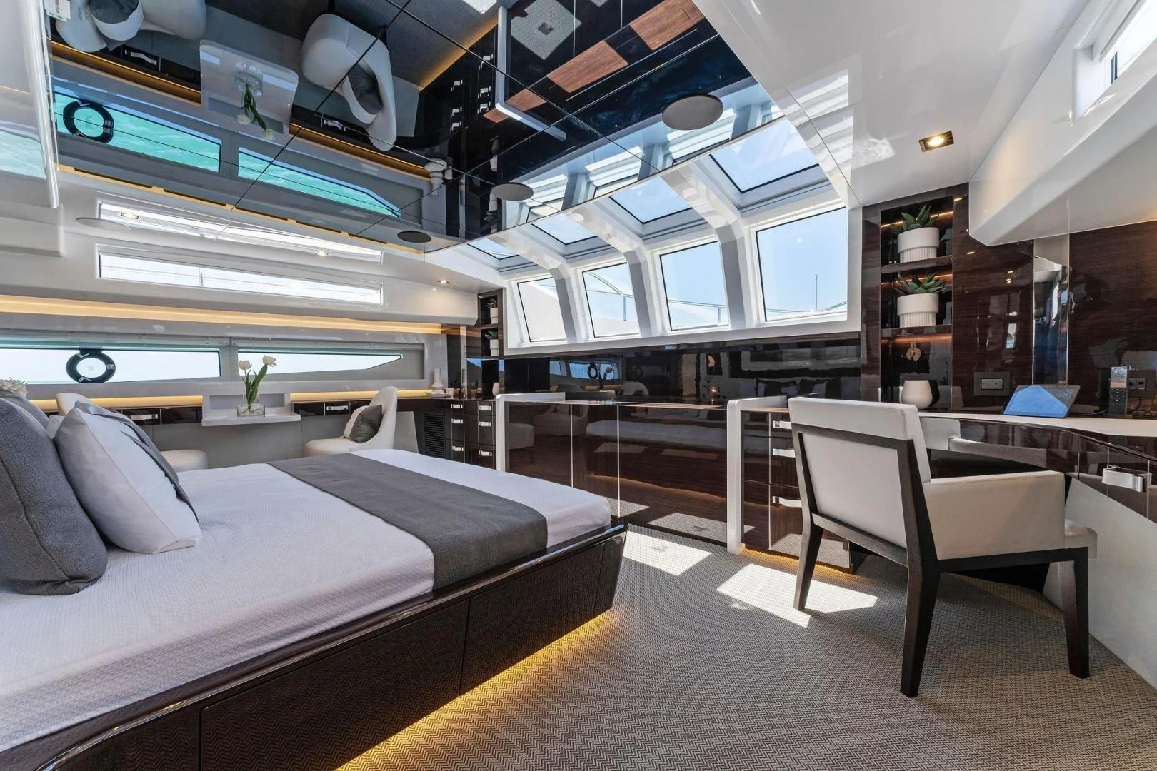 a room with a bed and desk aboard PEARL Yacht for Sale