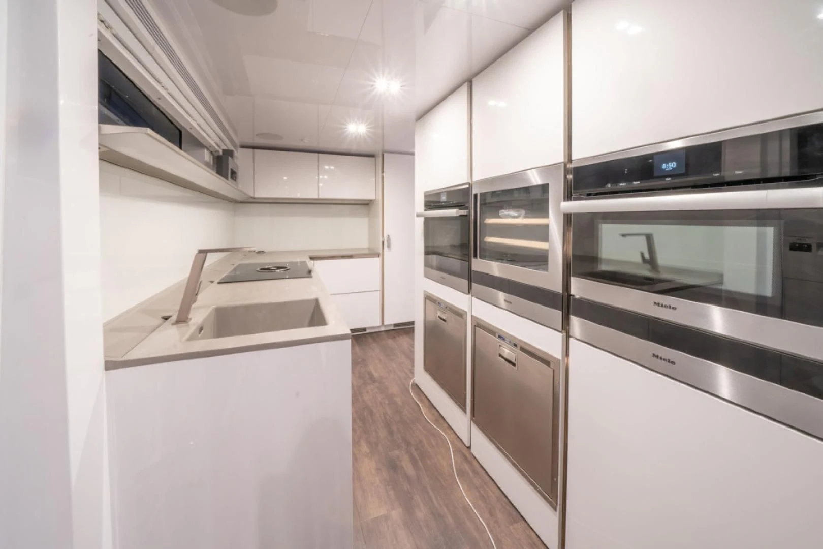 a kitchen with white cabinets aboard PEARL Yacht for Sale