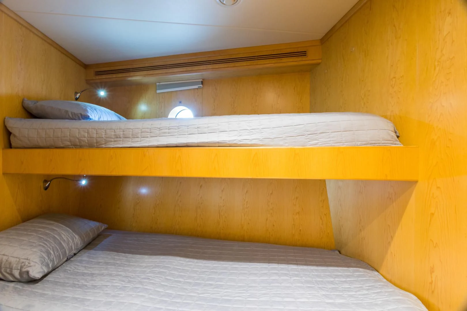 a bed with a wooden headboard aboard MY AURORA Yacht for Sale