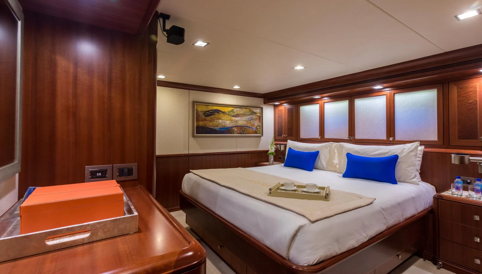 a bed with a white sheet and blue pillows aboard MY AURORA Yacht for Sale