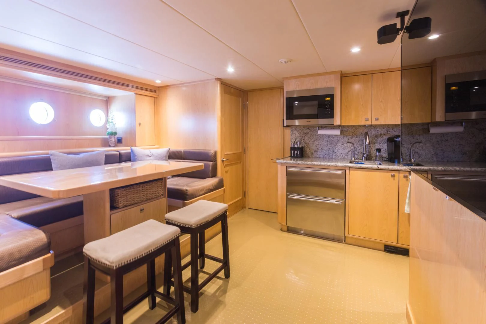 a kitchen with a bar and stools aboard MY AURORA Yacht for Sale