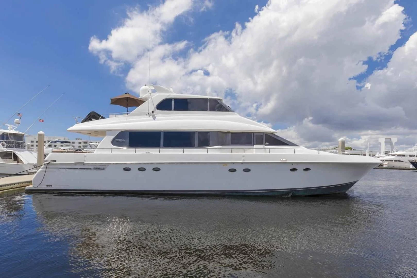 a white yacht docked at a pier aboard OHANA Yacht for Sale