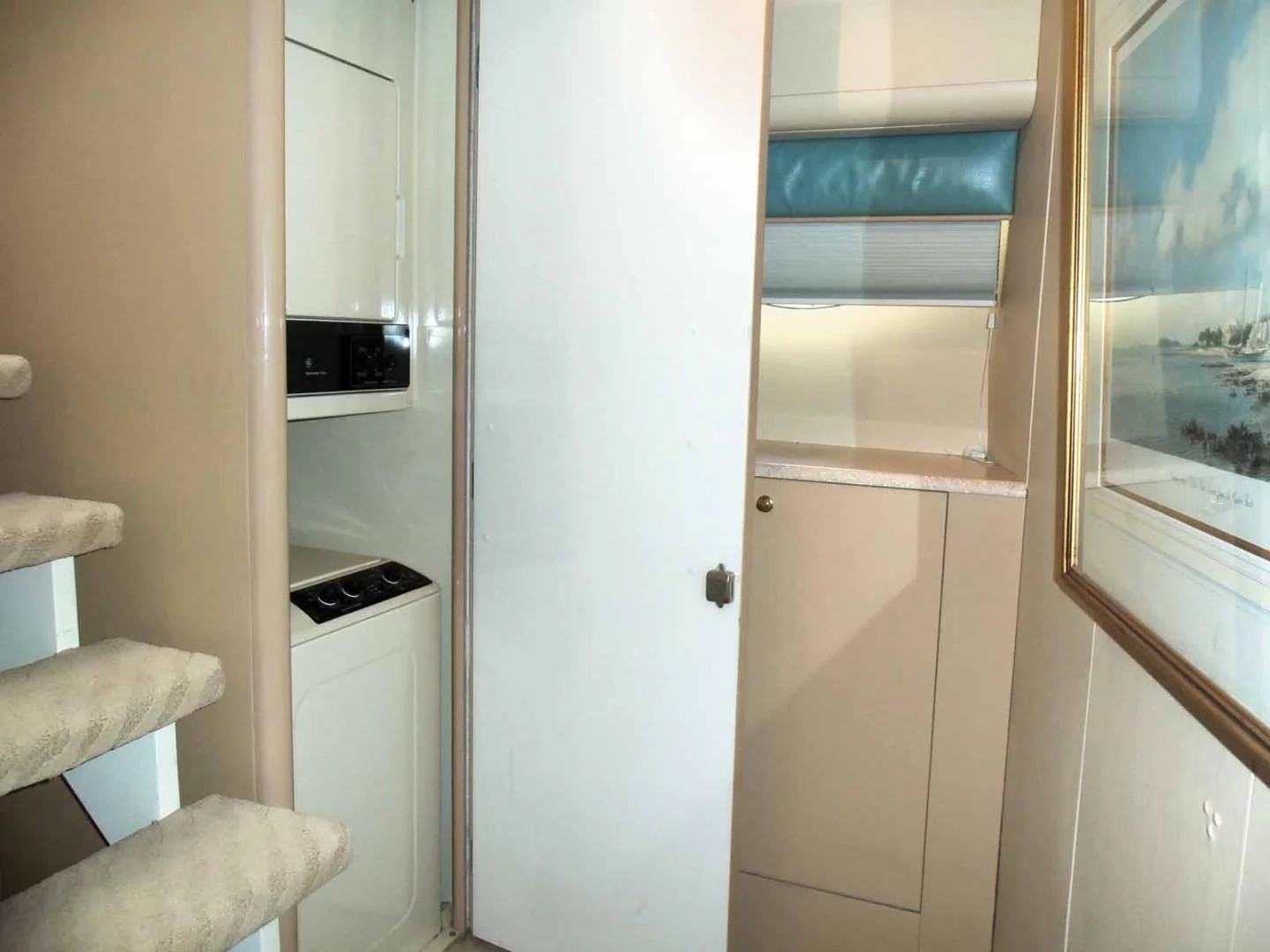 a small kitchen with a small refrigerator aboard OHANA Yacht for Sale