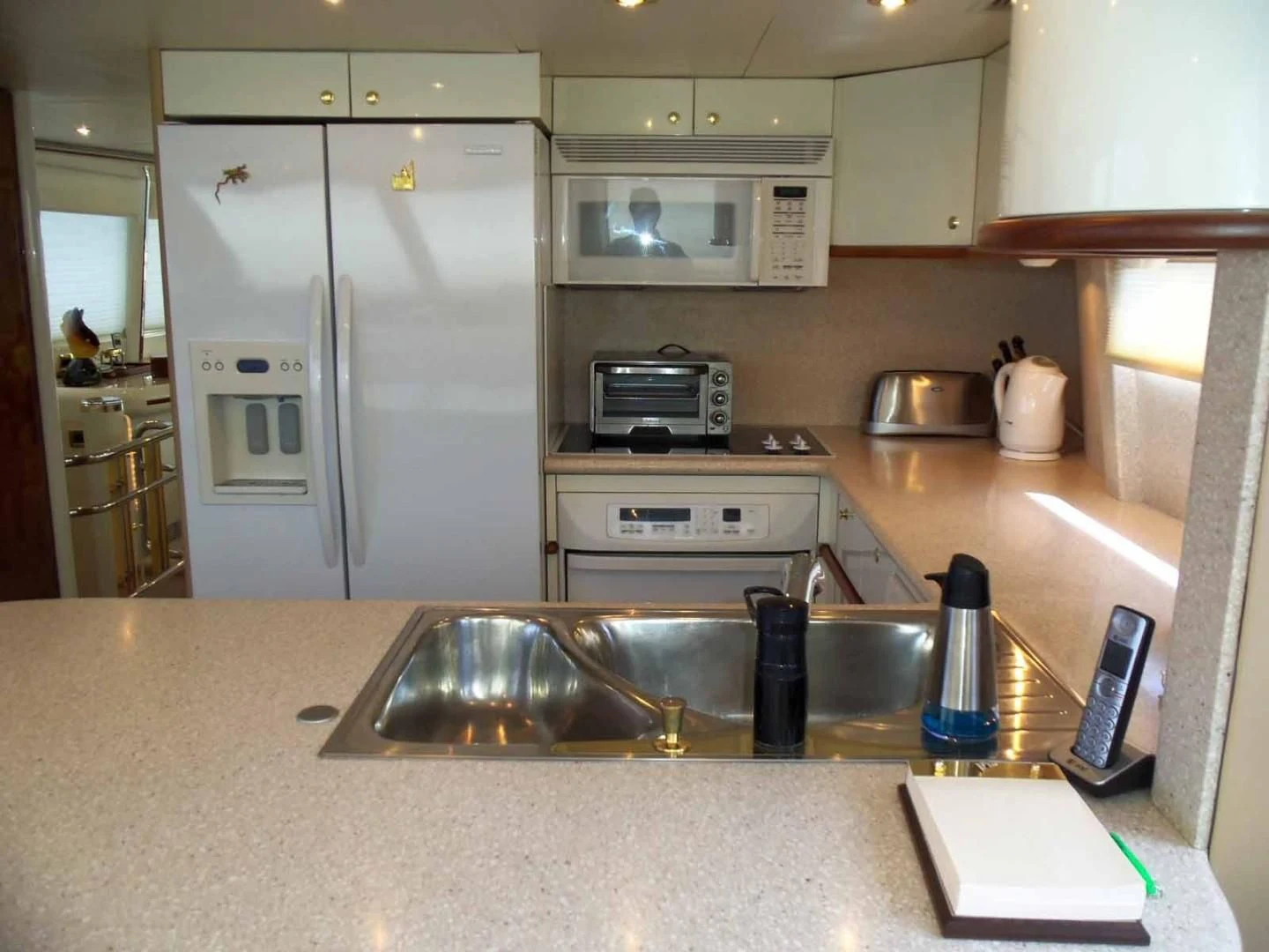 a kitchen with a sink and a refrigerator aboard OHANA Yacht for Sale