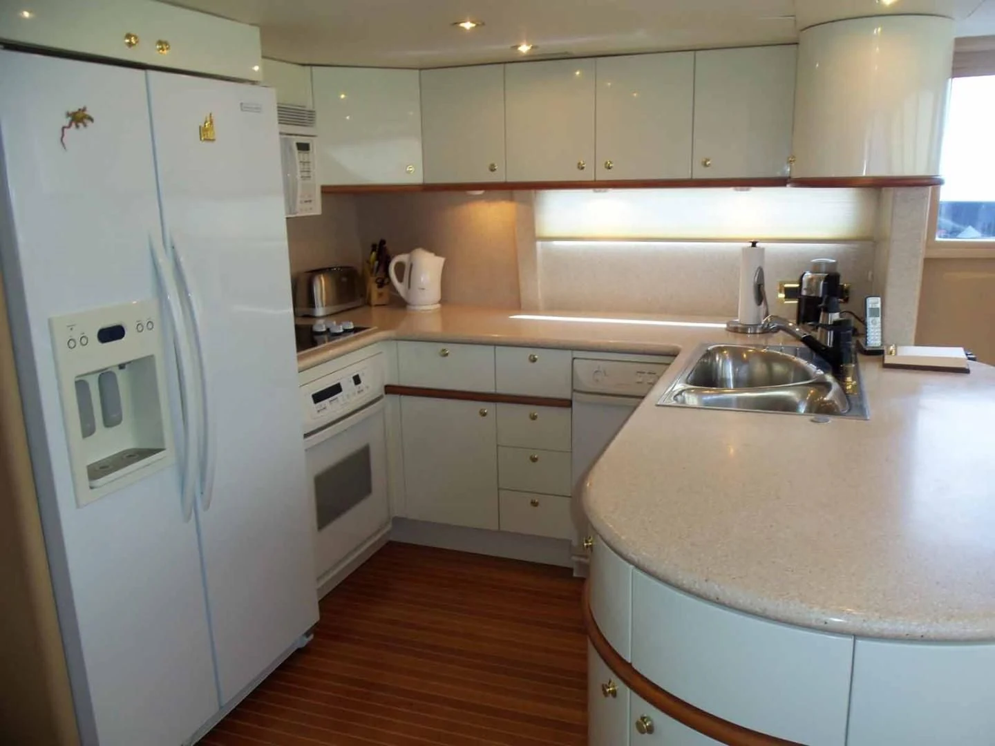 a kitchen with white cabinets aboard OHANA Yacht for Sale
