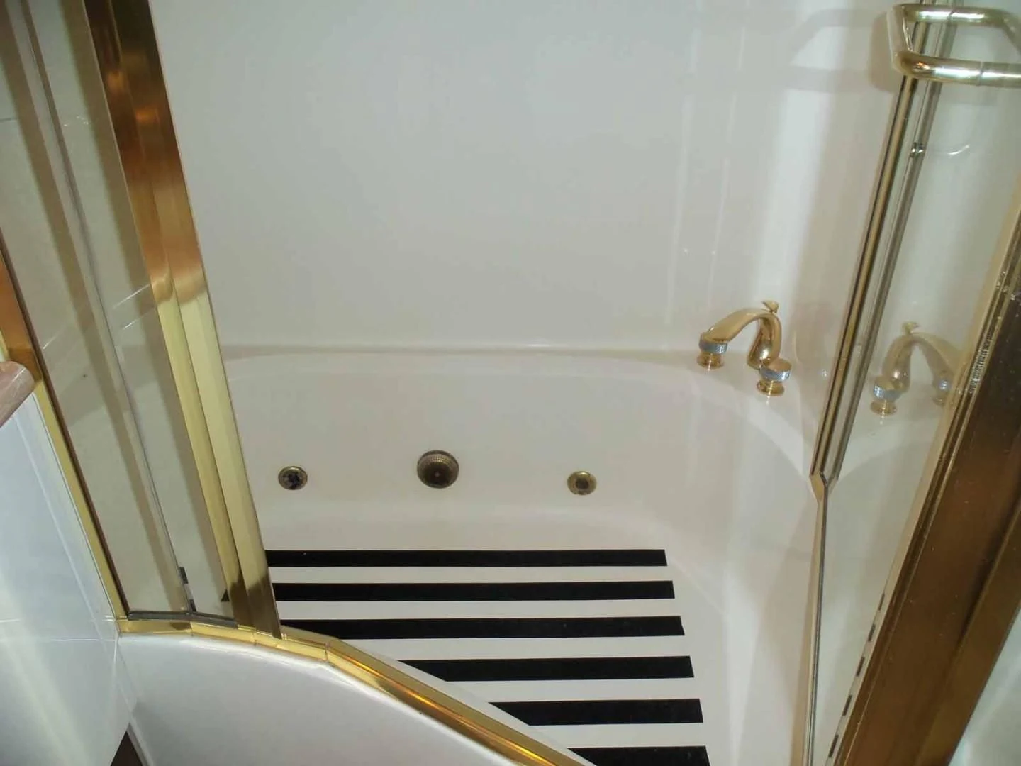 a bathtub with a shower head aboard OHANA Yacht for Sale