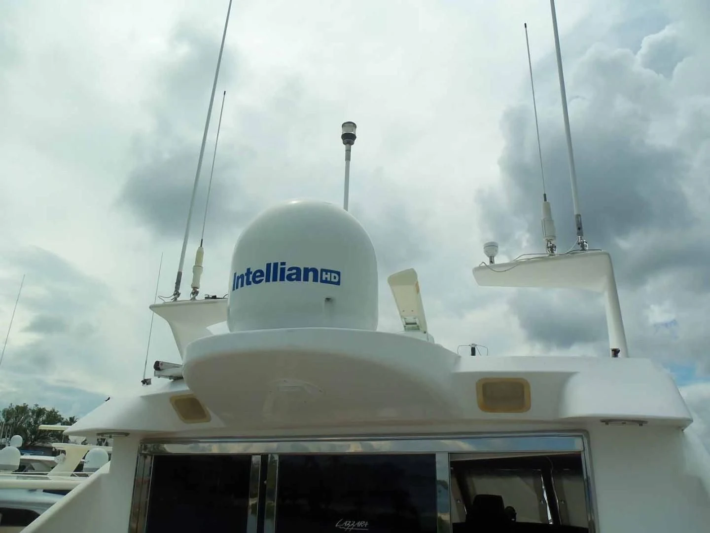 a white boat with a white domed roof and a white tower on a cloudy day aboard OHANA Yacht for Sale