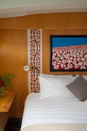 a bed with a painting on the wall aboard DOUCE FRANCE Yacht for Sale