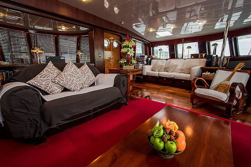 a living room with a large bed and a table with fruit on it aboard DOUCE FRANCE Yacht for Sale