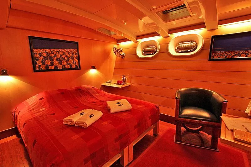 a bed and chair in a room aboard DOUCE FRANCE Yacht for Sale