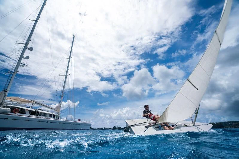 a man on a boat with a sail aboard DOUCE FRANCE Yacht for Sale
