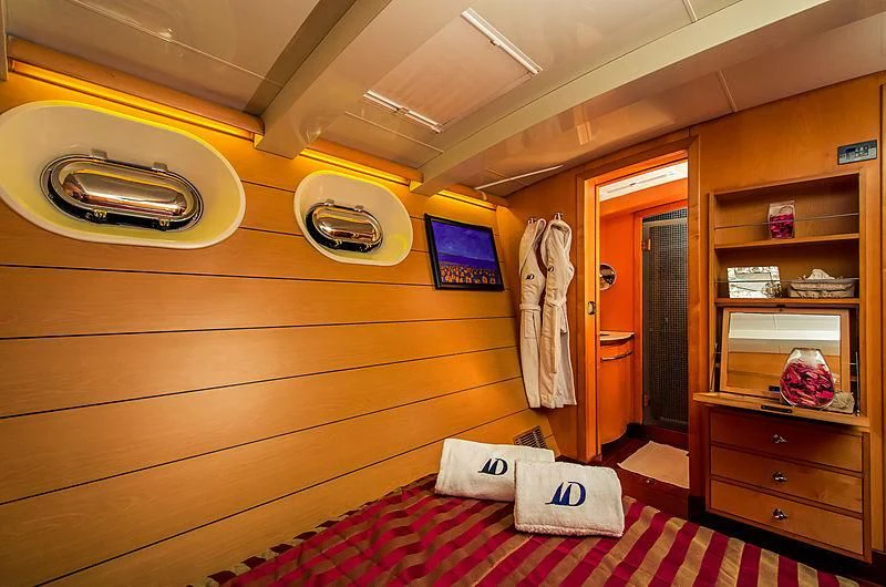 a room with a bed and a shelf with clothes on it aboard DOUCE FRANCE Yacht for Sale