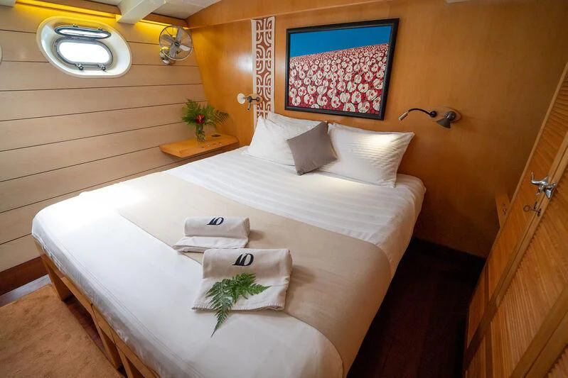 a bed with a white sheet and pillows on it aboard DOUCE FRANCE Yacht for Sale