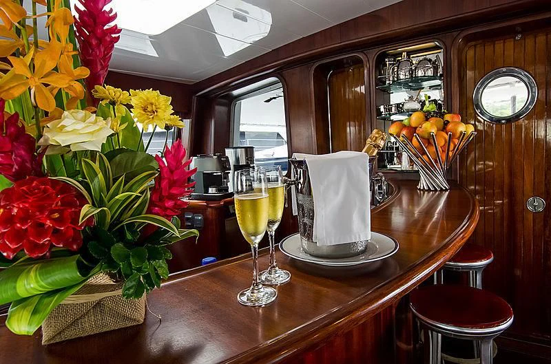 a table with a glass of wine and flowers on it aboard DOUCE FRANCE Yacht for Sale