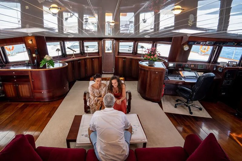 a group of people sitting in a room with a table and chairs aboard DOUCE FRANCE Yacht for Sale