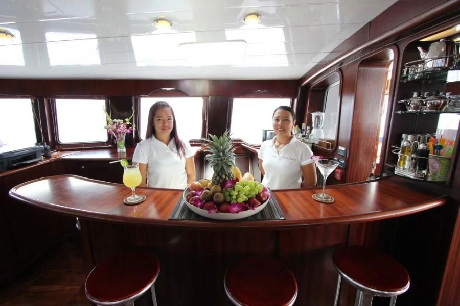 a couple of women sitting at a bar with a plate of food aboard DOUCE FRANCE Yacht for Sale