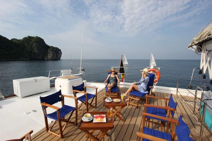 a couple of people sitting on a boat on the water aboard DOUCE FRANCE Yacht for Sale