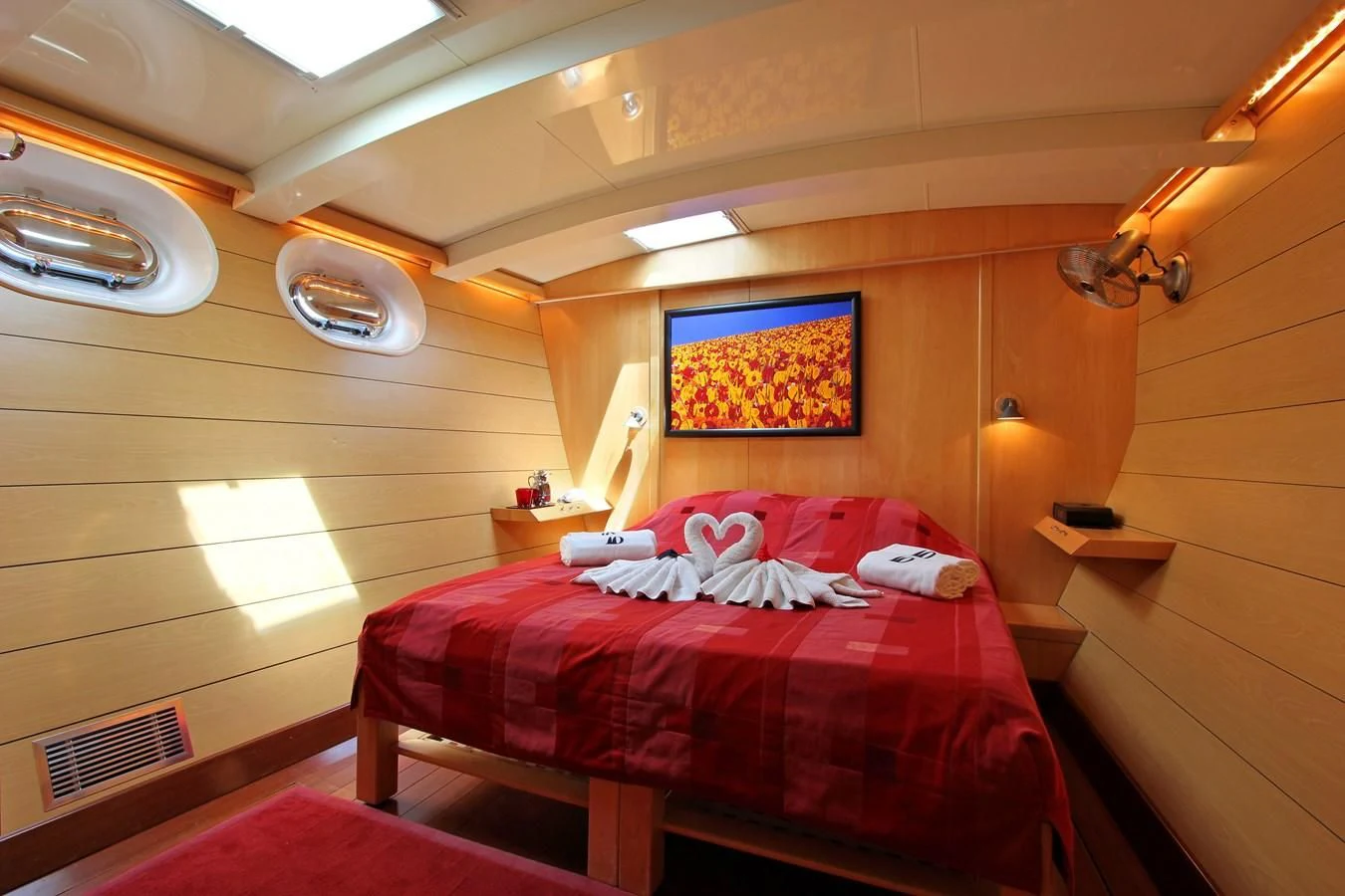 a room with a bed and a lamp aboard DOUCE FRANCE Yacht for Sale
