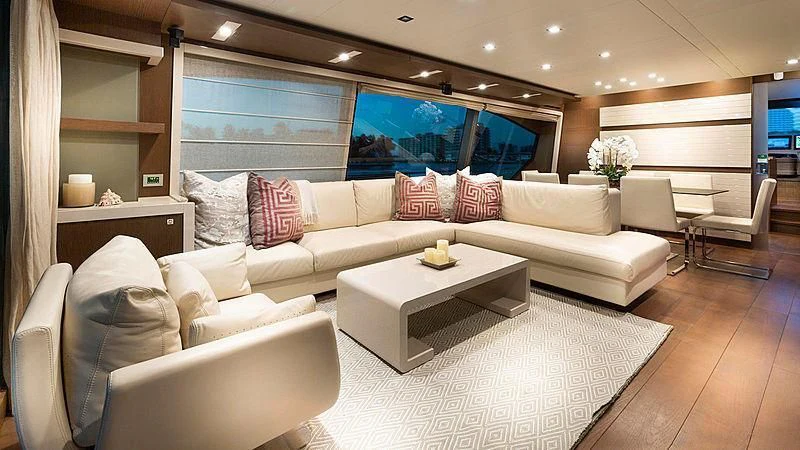 a living room with a large white sofa and a large window aboard HOYA SAXA Yacht for Sale