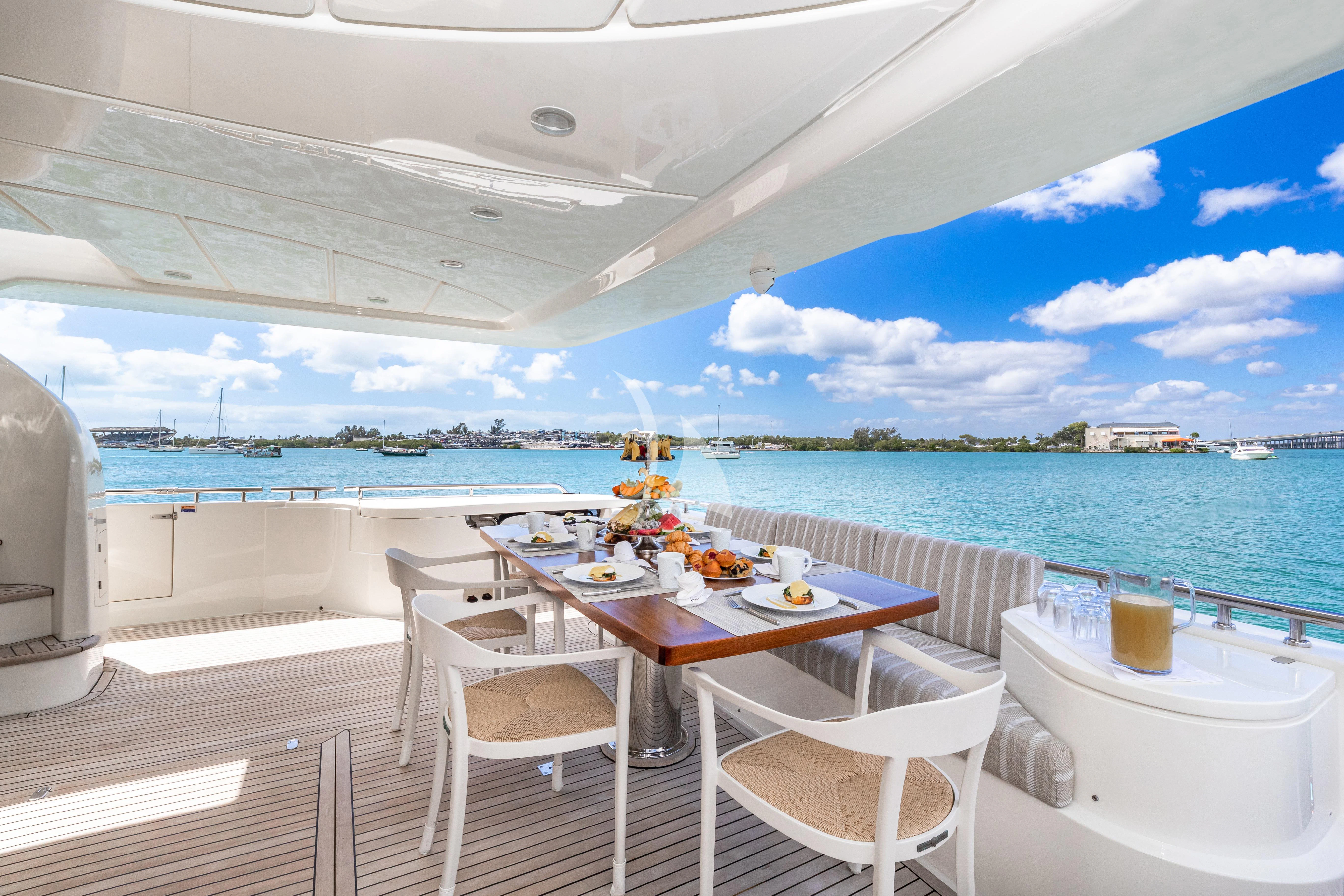 a table and chairs on a deck overlooking a body of water aboard HOYA SAXA Yacht for Sale