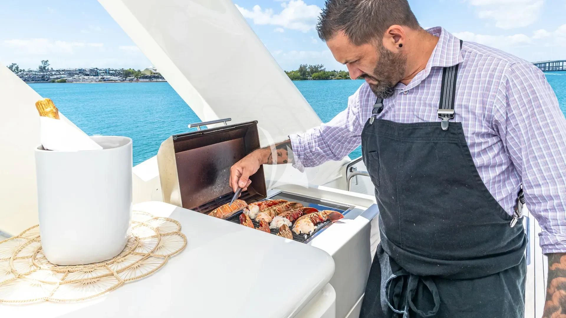 a man grilling food on a boat aboard HOYA SAXA Yacht for Sale