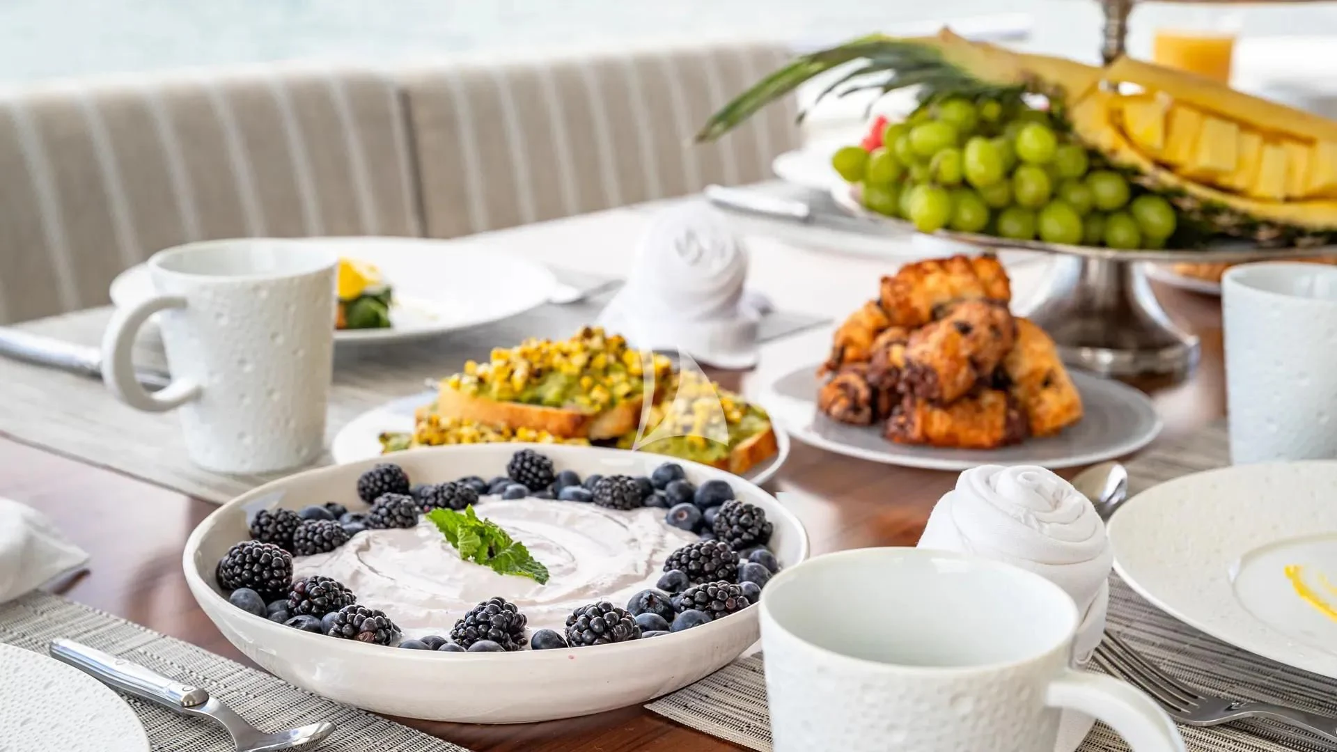 a table with plates of food and cups aboard HOYA SAXA Yacht for Sale