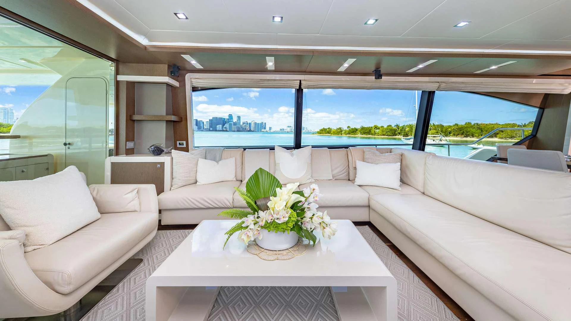 a white couch and a table in a room with a large window aboard HOYA SAXA Yacht for Sale