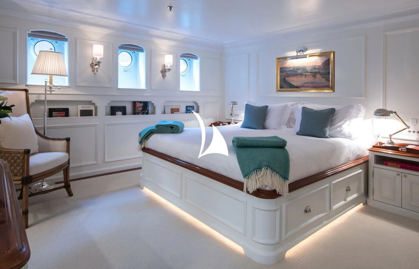a bedroom with a bed and a chair aboard HAIDA 1929 Yacht for Sale