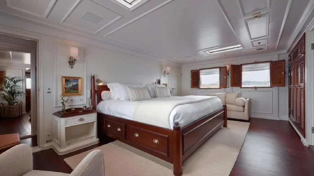 a large bedroom with a large bed aboard HAIDA 1929 Yacht for Sale