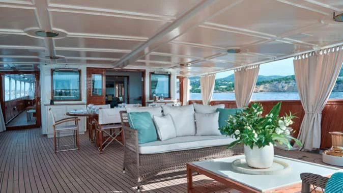 a living room with a couch and a table aboard HAIDA 1929 Yacht for Sale