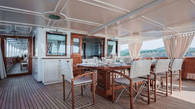 a dining room with tables and chairs aboard HAIDA 1929 Yacht for Sale
