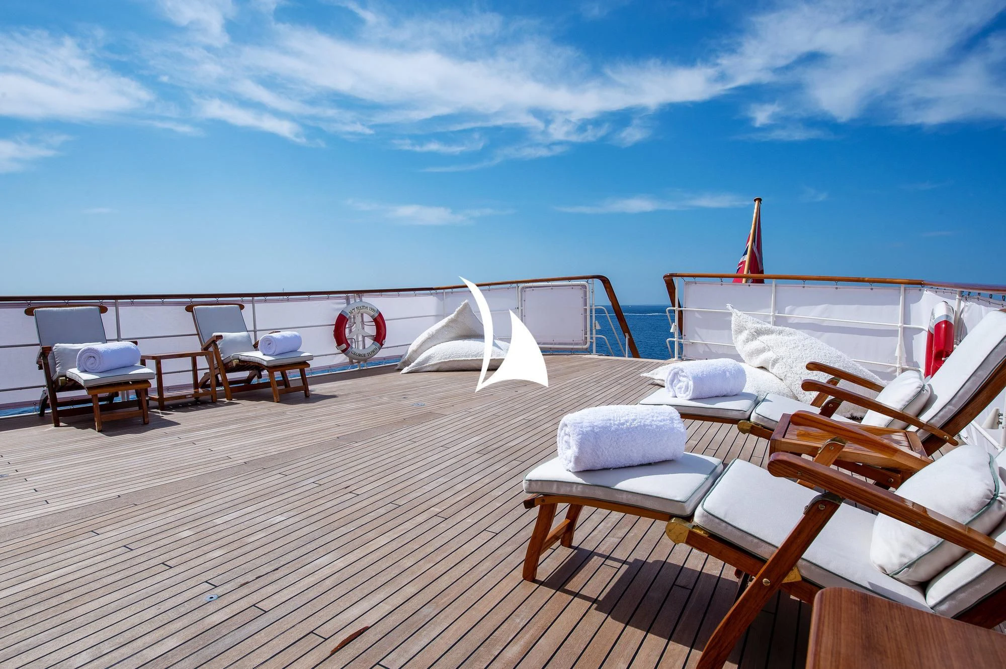 a deck with chairs and tables on it aboard HAIDA 1929 Yacht for Sale
