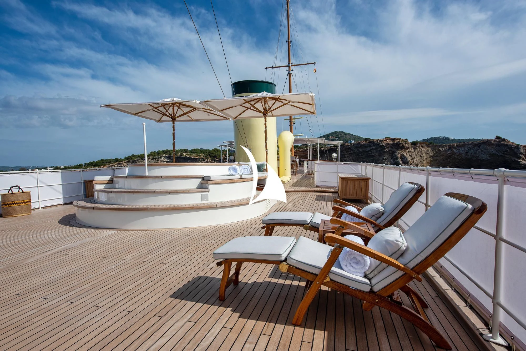 a deck with a table and chairs on it aboard HAIDA 1929 Yacht for Sale