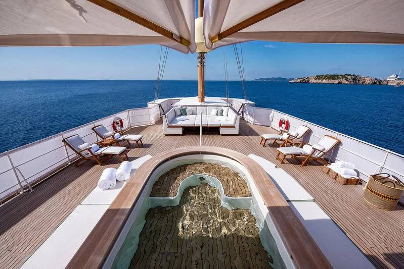 a lounge area with a large umbrella aboard HAIDA 1929 Yacht for Sale