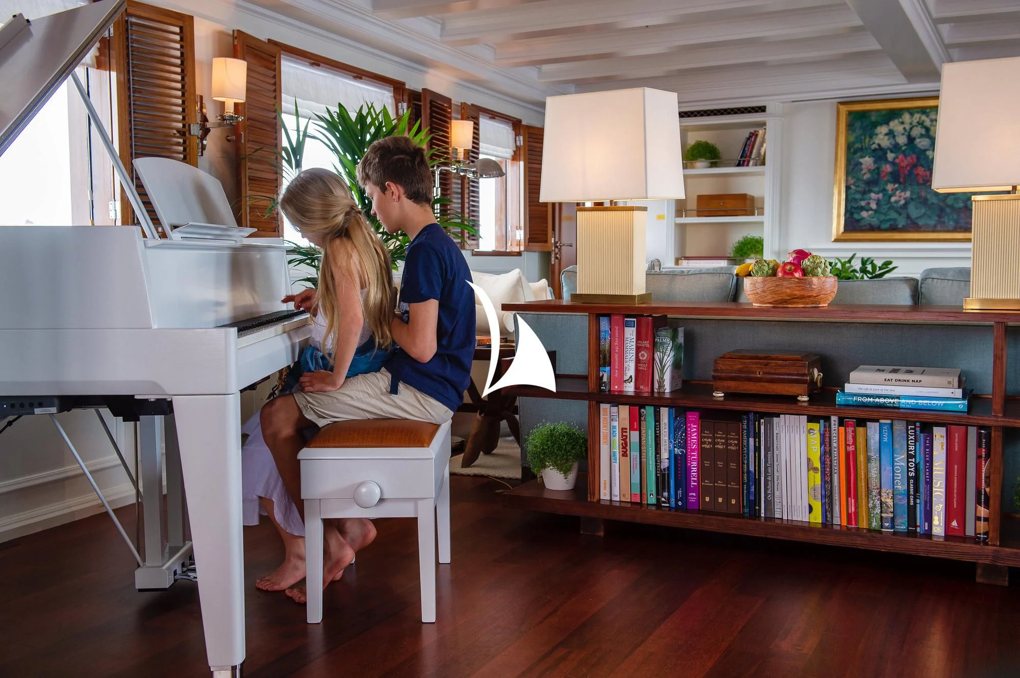 a man and woman sitting at a table in a library aboard HAIDA 1929 Yacht for Sale